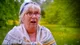 Dawn Hollyoak outside the tent in a patterned shawl and a blue headscarf, eyes wide and mouth open, stunned