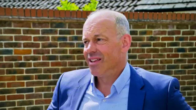 Phil Spencer in a blue jacket and open-necked shirt in front of a brick wall, mid-sentence, a few seconds after the chuff