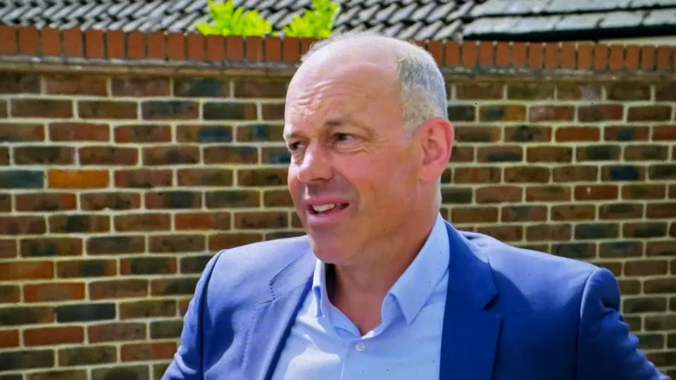 Phil Spencer in a blue jacket and open-necked shirt in front of a brick wall, mid-sentence, a few seconds after the chuff