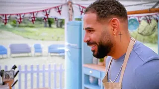 Sandro Farmhouse in the tent in a blue T-shirt and apron, in profile, grinning